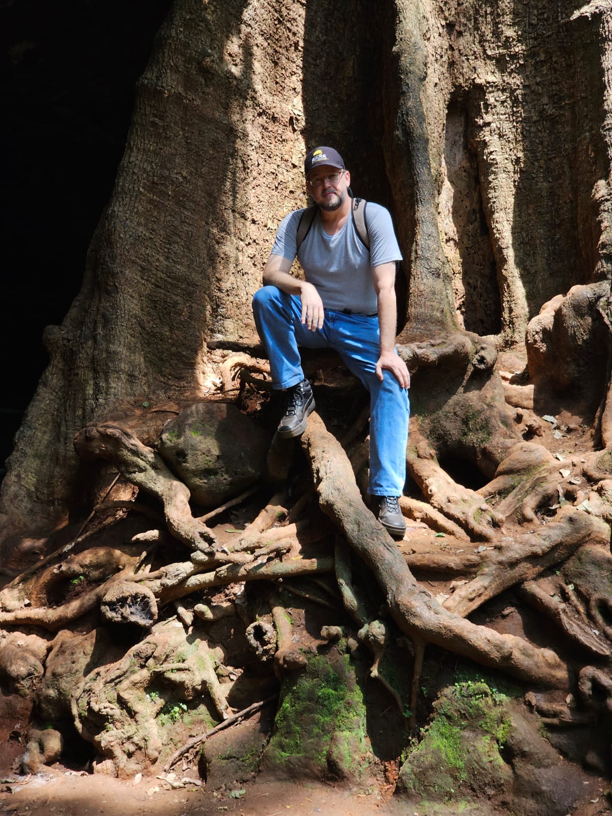 Jeremy sitting on a large tree root